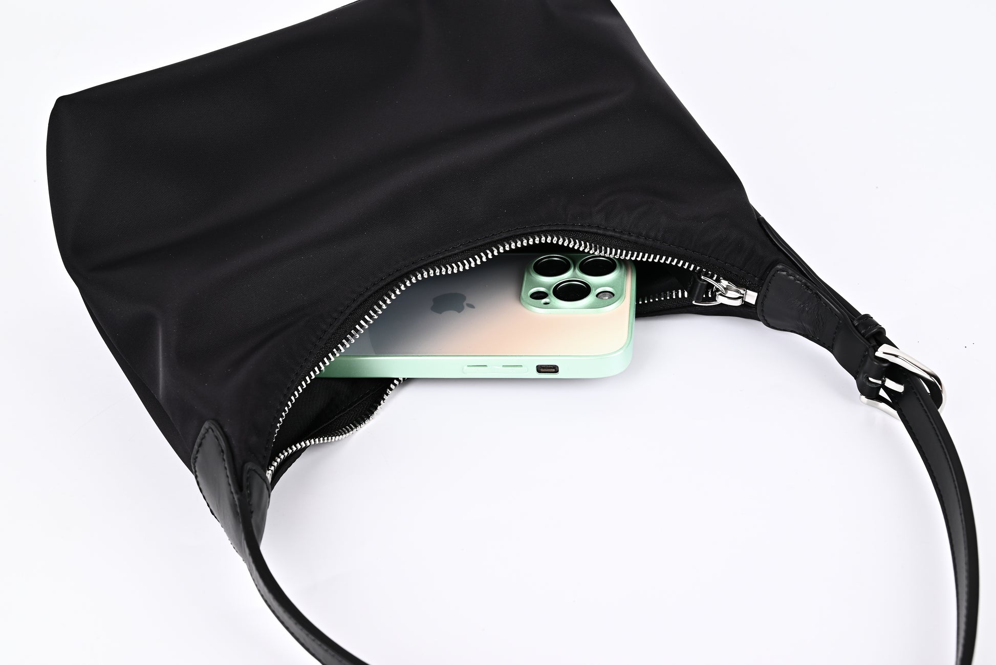 Black nylon hobo shoulder bag capacity demonstration with iPhone inside, showing large storage space"
"Practical black nylon hobo bag with roomy interior that easily fits phone and daily essentials