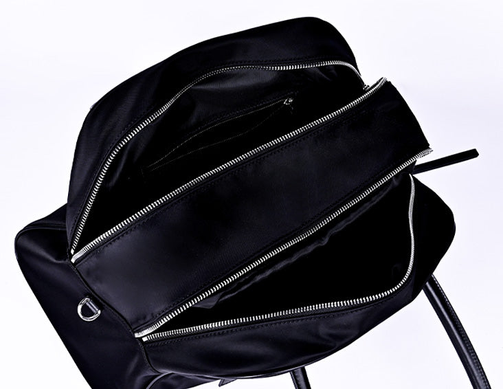 Black nylon commuter tote bag interior showing large capacity with multiple zipper pockets and organized storage compartments